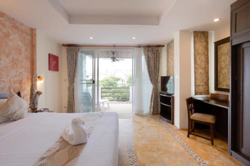 a bedroom with a bed and a desk and a window at My Way Hua Hin Music Hotel SHA Extra Plus in Hua Hin