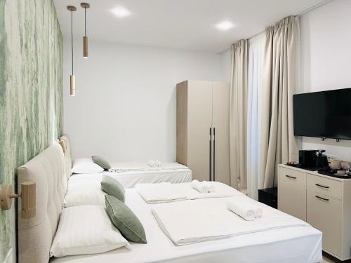 a room with three beds and a flat screen tv at Flowers Premium Apartments & Rooms in Zagreb