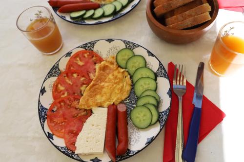 a plate of food with eggs and vegetables on a table at Berat Dream Apartment in Berat