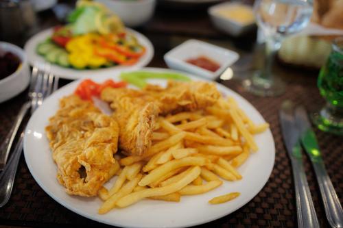 a plate of food with french fries on a table at Amoun Hotel Alexandria in Alexandria