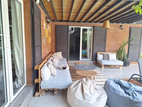 a patio with a couch and a table on a porch at Villa Roseaux heated pool Marrakech in Najem