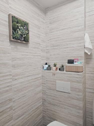 a bathroom with a toilet and flowers on the wall at Ela Home Concept Residence in Iaşi