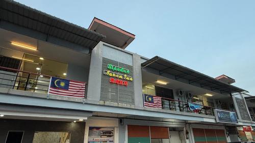 a building with a balcony with an american flag at Sipadan Crystal Haven Inn in Semporna