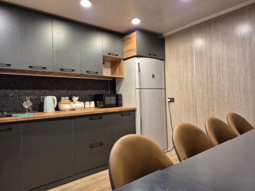 a kitchen with a table and chairs and a refrigerator at Hostel Navi Osh in Osh