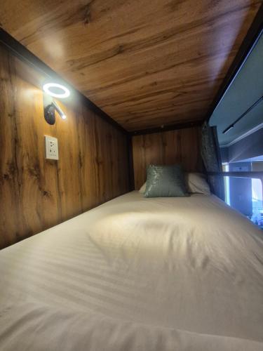 a bed in a room with a light on the wall at Hostel Navi Osh in Osh
