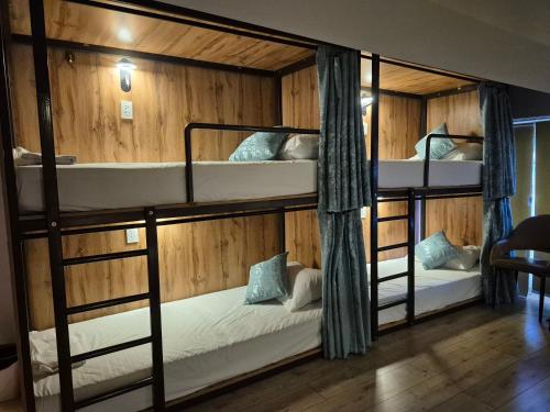 two bunk beds in a room with wooden walls at Hostel Navi Osh in Osh