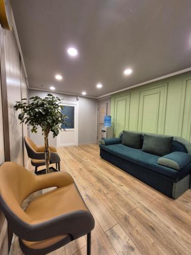 a living room with a blue couch and chairs at Hostel Navi Osh in Osh