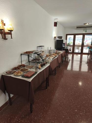 una fila di tavoli con sopra piatti di cibo di Hotel Blason Junior a Peñíscola