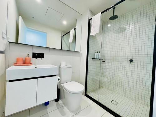 a bathroom with a toilet and a glass shower at Comfy Unit in front of Crown with Free Parking in Melbourne