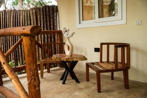 a room with a chair and a vase on a table at Hostel 197 in Nungwi