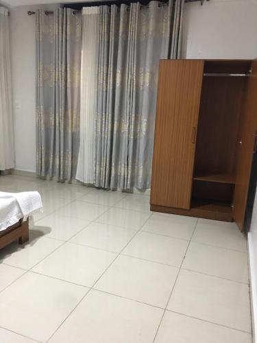 a bedroom with a cabinet and a white tile floor at Apple Luxury Apartments in Kigali
