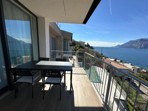 a balcony with a table and chairs and the ocean at My Lake Apartments in Malcesine