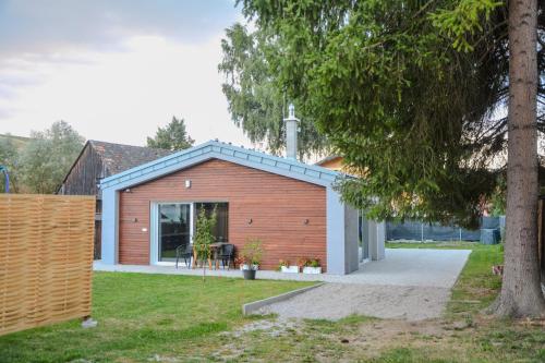 ein Haus mit einer Holzfassade und einem Baum in der Unterkunft Bungalov Vlnka in Vlachy