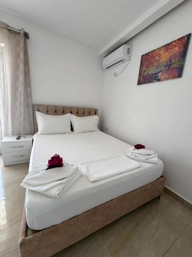 a bedroom with a white bed with red flowers on it at Villa Festim Ksamil in Ksamil