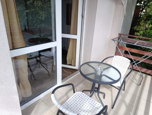 a patio with a table and chairs on a balcony at Apartments Nebojša in Soko Banja