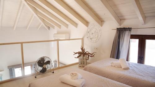 Un dormitorio con dos camas y un ventilador. en Villa Aristoteles, en Halki