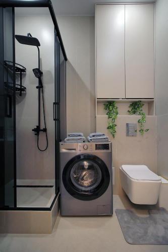 a bathroom with a washing machine and a toilet at Central Light Apartment in Almaty