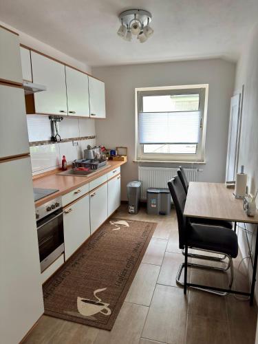 a kitchen with white cabinets and a table with chairs at Ataman in Hessisch Oldendorf