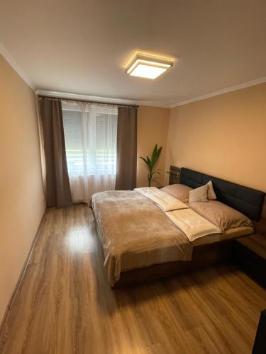 a bedroom with a bed and a window at Anna Vendégház Sárospatak in Sárospatak