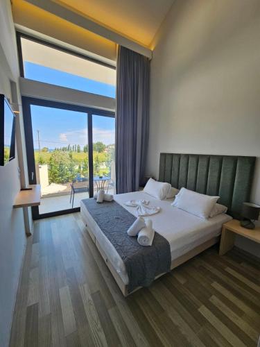 a bedroom with a large bed and a large window at Selyria Resort in Tsilivi