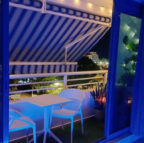 a table and chairs on a balcony at night at Charmant studio avec parking et terrasse à Papeete in Papeete