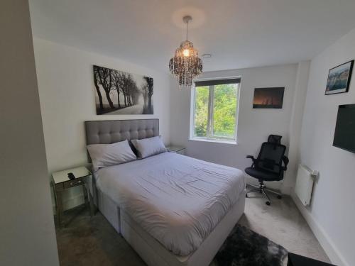 a bedroom with a bed and a chair and a chandelier at Sweet Ivy 1 Bedroom Tottenham in London