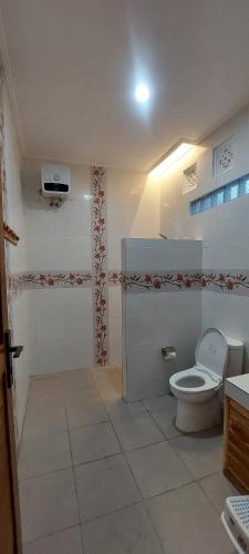 a white bathroom with a toilet and a shower at Villa LOVE INNA, Private, modern with AirCon and Pool in Lovina