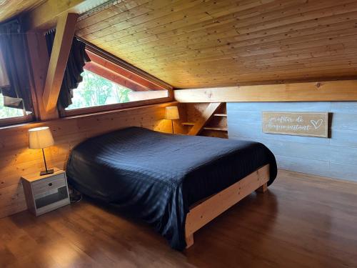 a bedroom with a bed in a wooden cabin at Chalet Cosy avec terrasse plein sud, 2 chambres, au cœur de la Haute-Savoie in Châtillon-sur-Cluses