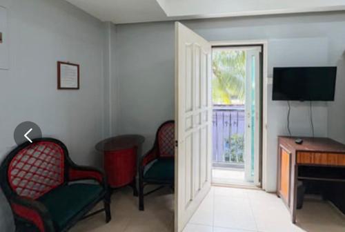 a room with two chairs and a desk and a television at Hotel Le Carmen in Cebu City