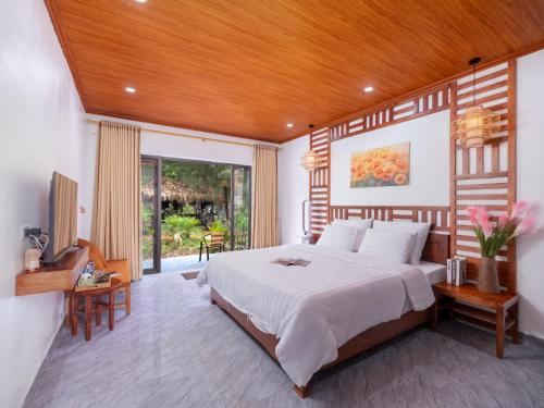a bedroom with a large bed with a wooden ceiling at Adumi Retreat Tam Cốc in Vũ Lâm