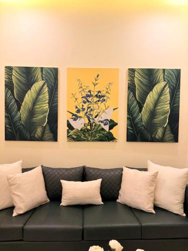 four paintings on a wall above a couch at Mountain view cottage in Murree