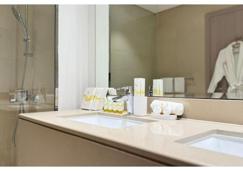 La salle de bains est pourvue de 2 lavabos et d'un miroir. dans l'établissement Yas Vista 2BR - Spacious Apartment with Pool & Balcony Near Yas Mall & Marina, à Abu Dhabi
