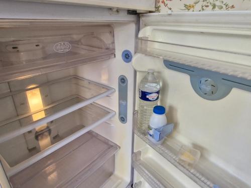 an open refrigerator with a bottle of water in it at Cosy cottage at rustic escapes 