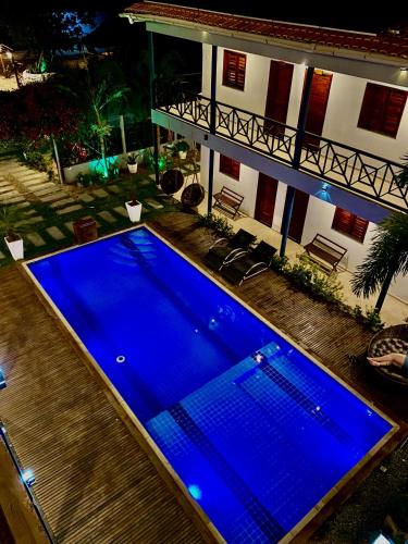 a large blue swimming pool in front of a house at Pousada Camocim Beach in Camocim