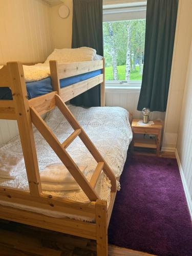 a bedroom with two bunk beds and a window at Casa Sápmi in Tromsø