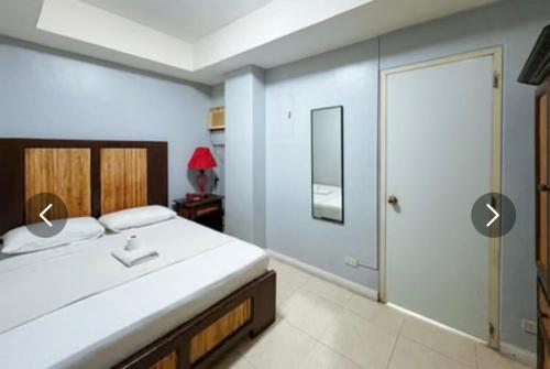 a bedroom with a bed and a walk in shower at Hotel Le Carmen in Cebu City