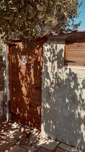 a wooden gate with a shadow of a tree at Nereid Bungalow in Phanaes