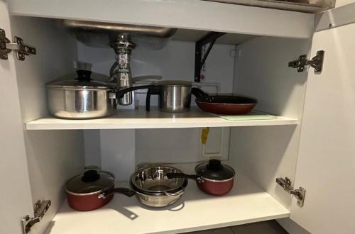 a kitchen shelf with pots and pans on it at Studio aconchegante e funcional in Sao Paulo