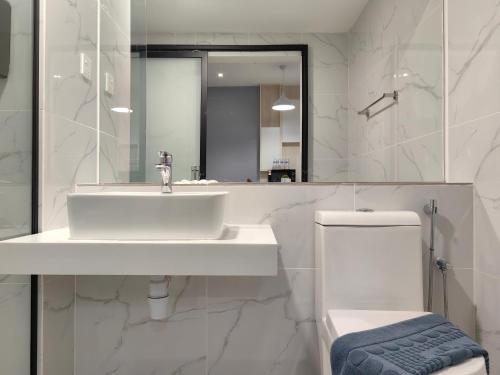 a bathroom with a sink and a toilet and a mirror at Vetro11 Beside QEH1 by JUNE Homestay in Kota Kinabalu