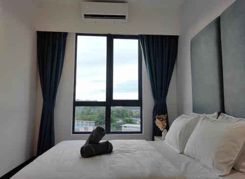 a bedroom with a white bed with a large window at Vetro11 Beside QEH1 by JUNE Homestay in Kota Kinabalu