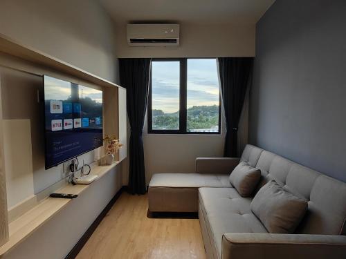 a living room with a couch and a flat screen tv at Vetro11 Beside QEH1 by JUNE Homestay in Kota Kinabalu