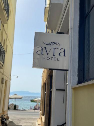 a sign for a hotel on the side of a building at Hotel Avra in Aegina Town