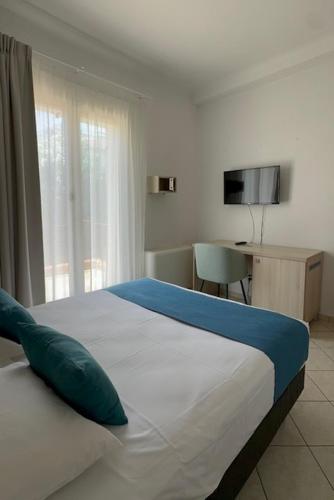 a bedroom with a bed and a desk and a television at Hotel et Appartements Reine D'Azur in Roquebrune-Cap-Martin