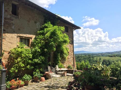 a brick building with a table and plants in front of it at Villa Pieve De' Pitti in Terricciola