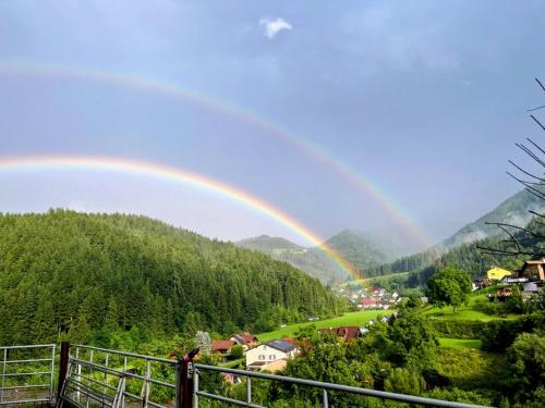a rainbow in the sky over a town with at Hofquartier Retzmoar - Familie Hörmann in Bruck an der Mur