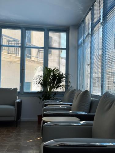 a row of couches in a waiting room with windows at Hotel Avra in Aegina Town