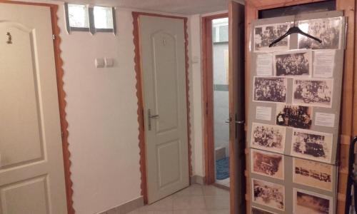 a hallway with a door with pictures on the wall at Hagyományőrző és múltidéző porta in Báta