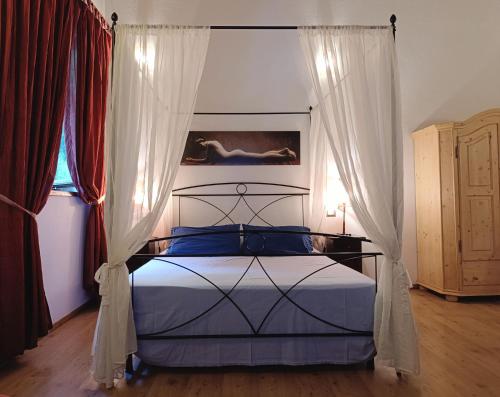 a bedroom with a bed with a canopy and curtains at Mulino Baiar in Stregna