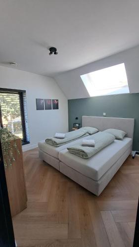 two beds in a large room with a skylight at Vakantiewoning OpdeBaan in Kaatsheuvel