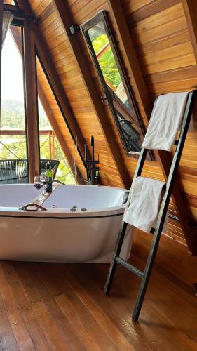 een badkamer met een bad en een stoel bij Chalé nascer do sol in Massaranduba